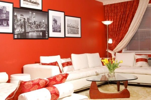 красные шторы в интерьере гостиной с белой мебелью и красными стенами