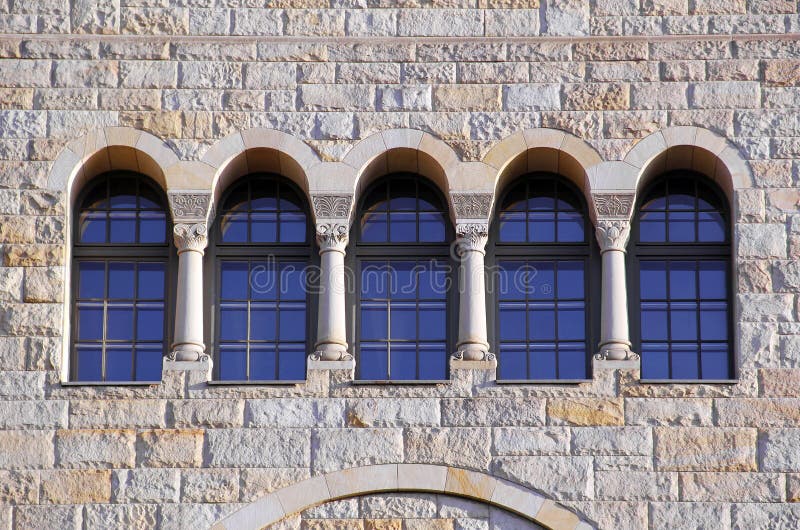 Five old windows with arches, columns and lattices on a stone wa royalty free stock image