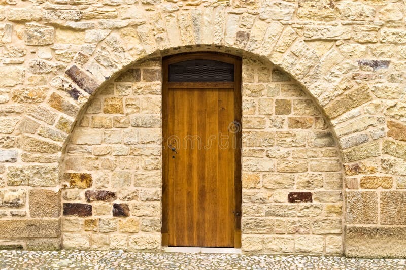 Isolated wooden door in a brick wall with a rounded arch Prague, Czech Republic stock image
