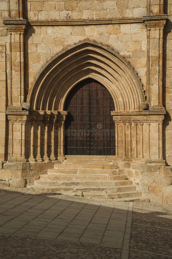 Wooden door with labored medieval stone arches and steps at Trujillo stock images